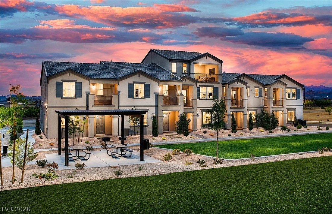 473 Filaree Place Henderson, NV 89015 - Photo 1 of 5 Experience modern living with private balconies and a scenic community green space at sunset.