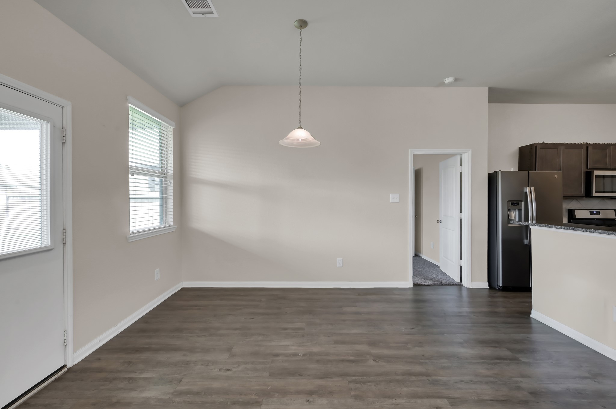 3532 Korina Way Conroe, TX 77306 - Photo 18 of 34 a view of a kitchen with a refrigerator a ceiling fan and wooden floor