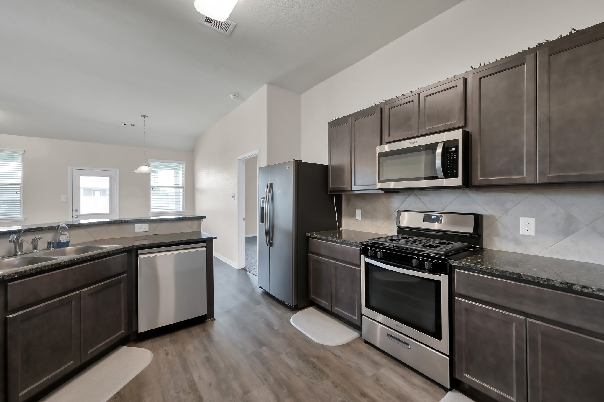 3532 Korina Way Conroe, TX 77306 - Photo 8 of 34 a kitchen with stainless steel appliances wooden cabinets and a stove top oven