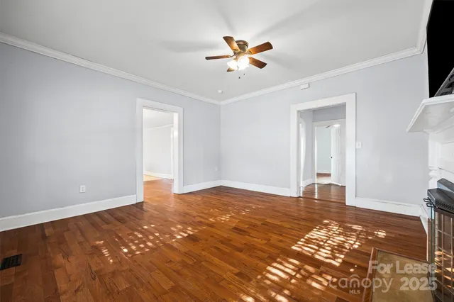 a view of a livingroom with wooden floor and a ceiling fan