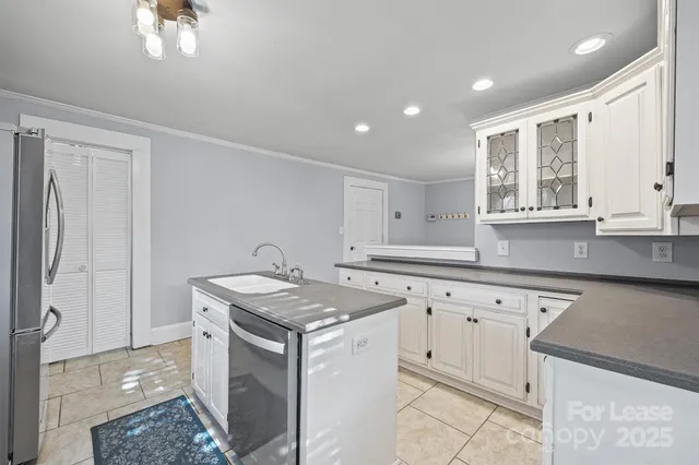 a kitchen with granite countertop a sink a stove a refrigerator and island with wooden floor