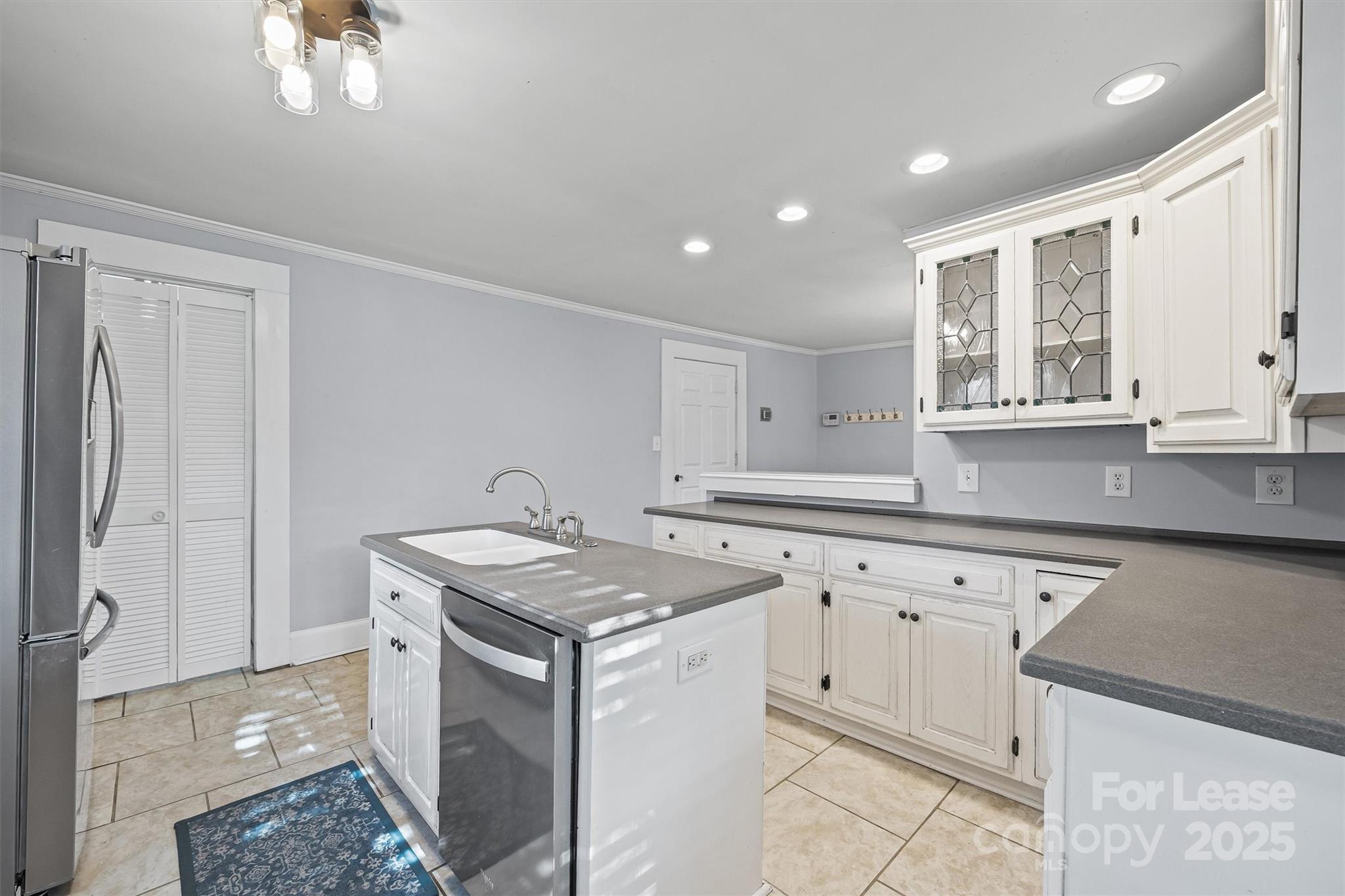 512 Banks Street Fort Mill, SC 29715 - Photo 18 of 30 a kitchen with granite countertop a sink a stove a refrigerator and island with wooden floor