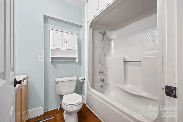a bathroom with a granite countertop toilet a sink and a bathtub