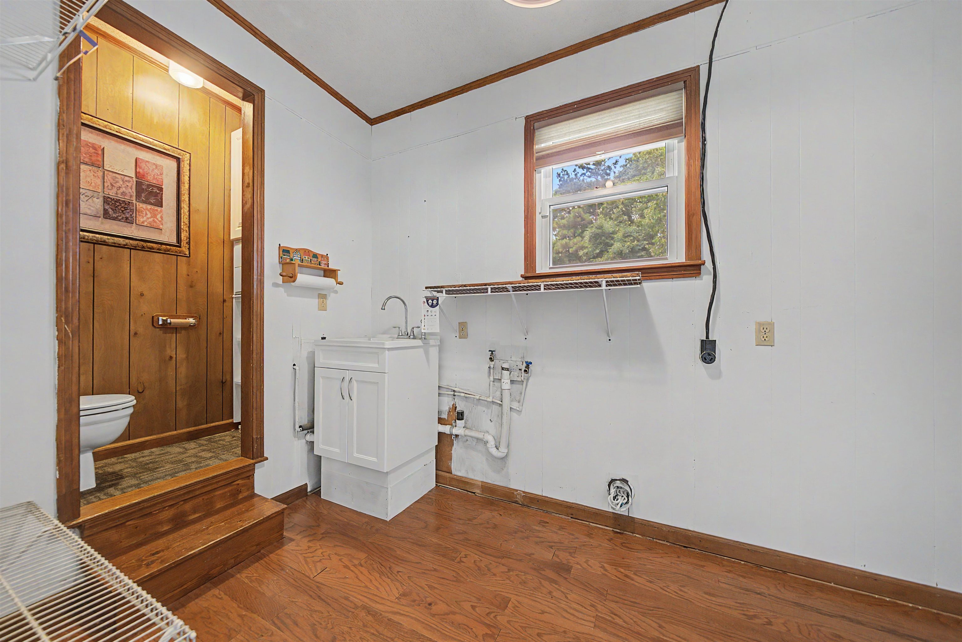 436 Skyline Road Selmer, TN 38375 - Photo 29 of 40 Utility room with wood-finish flooring and a white utility sink cabinet