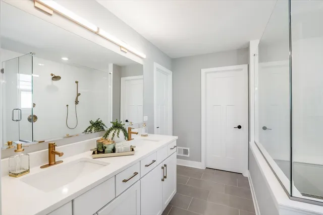 a bathroom with a double vanity sink mirror double and shower