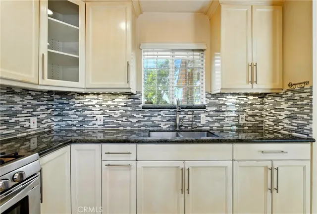 a kitchen with granite countertop white cabinets and a window