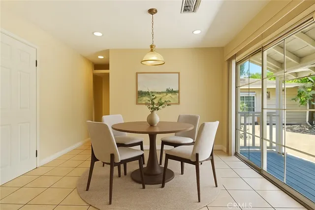 a dining room with furniture a chandelier and wooden floor