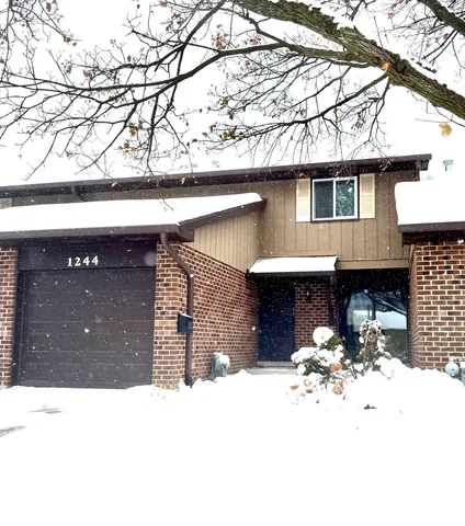 a view of a house with a yard covered in snow