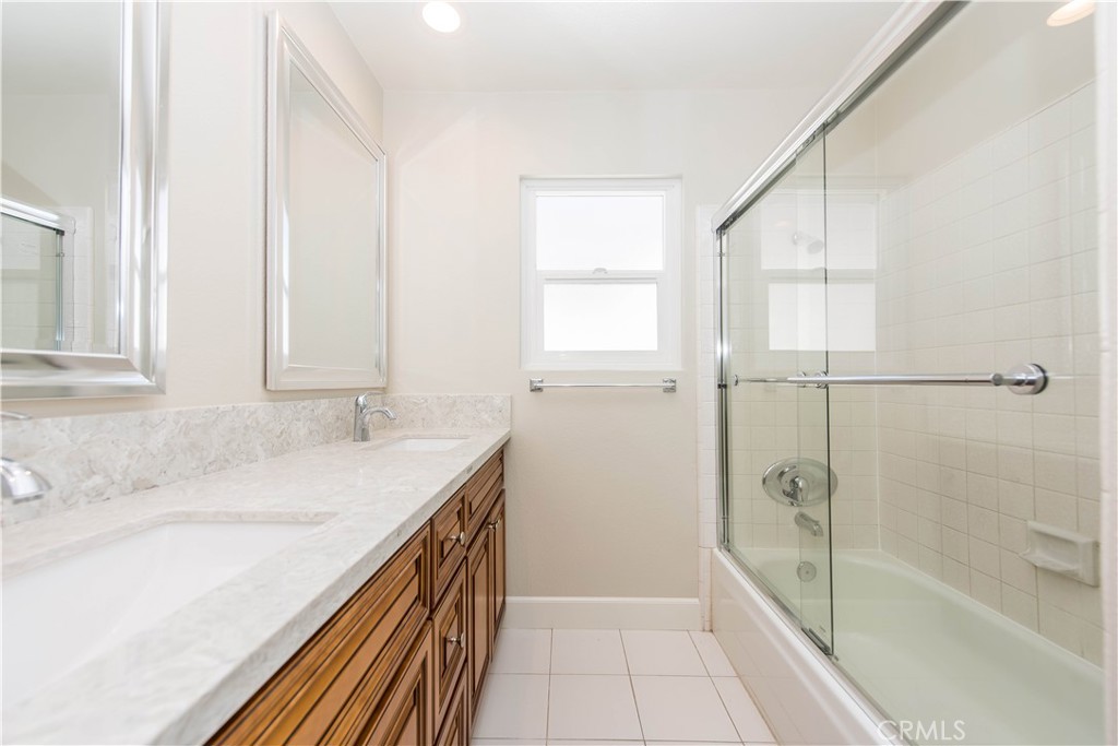 17 Palermo Irvine, CA 92614 - Photo 11 of 17 a bathroom with a granite countertop sink a mirror and a bathtub