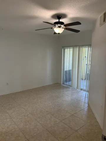 a view of an empty room with a chandelier fan