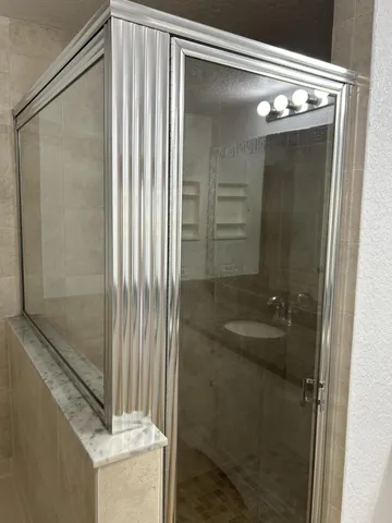 a bathroom with a shower and a sink