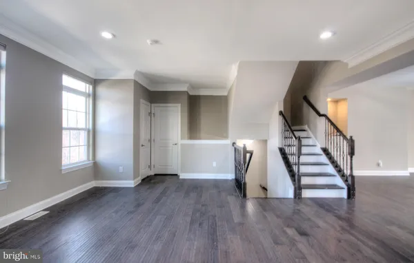 a view of staircase with railing and white walls