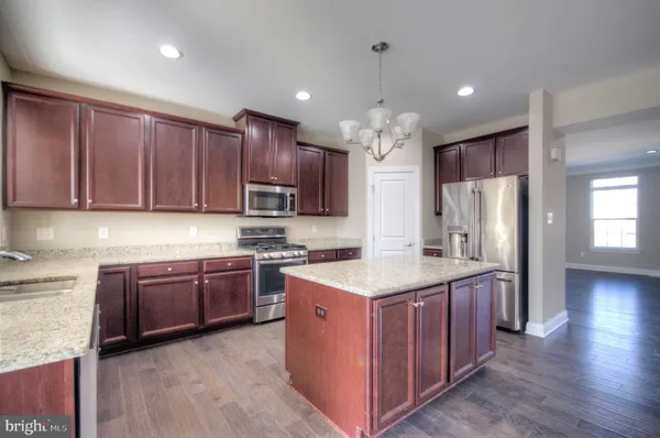 a kitchen with stainless steel appliances granite countertop a refrigerator a sink and a stove