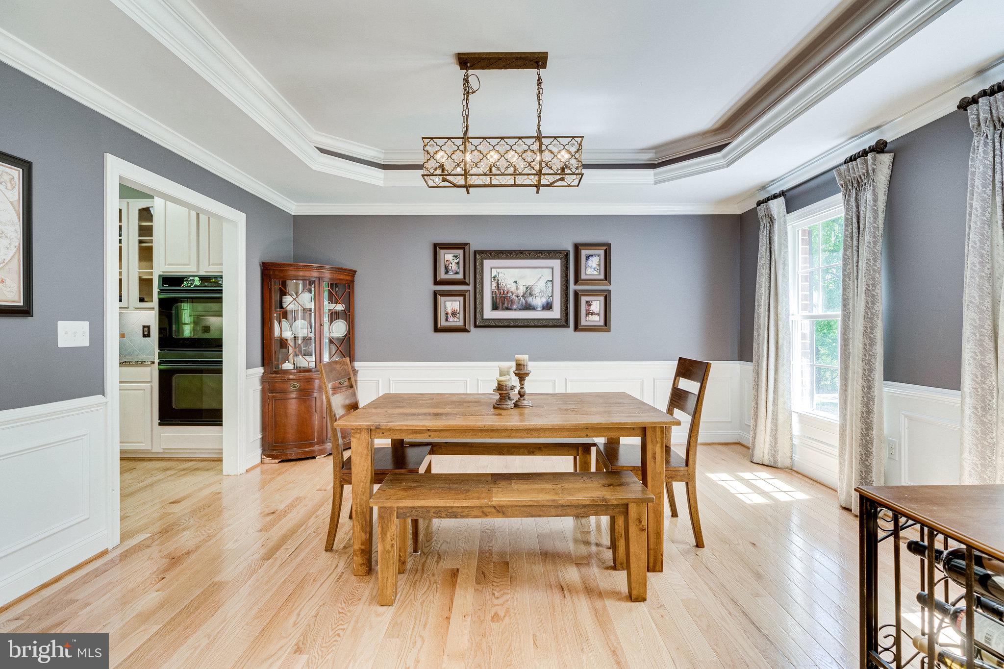 7802 Creekside View Lane Springfield, VA 22153 - Photo 12 of 107 a view of a dining room with furniture wooden floor and a chandelier