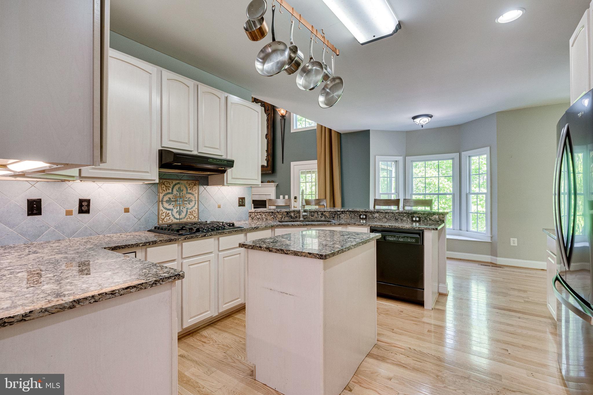 7802 Creekside View Lane Springfield, VA 22153 - Photo 16 of 107 a kitchen with stainless steel appliances granite countertop a sink a stove and a wooden floors