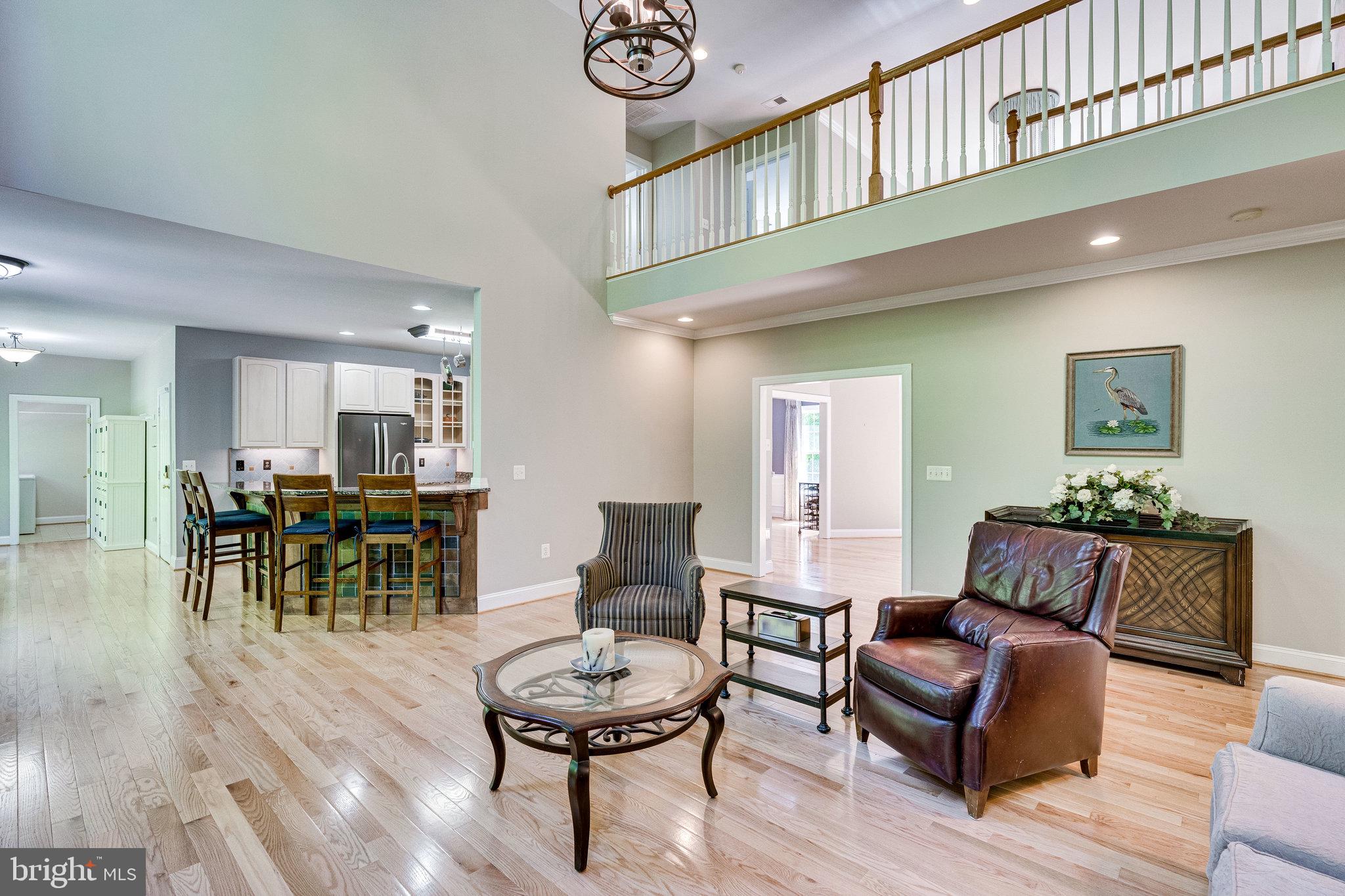 7802 Creekside View Lane Springfield, VA 22153 - Photo 29 of 107 a living room with furniture a table and kitchen view
