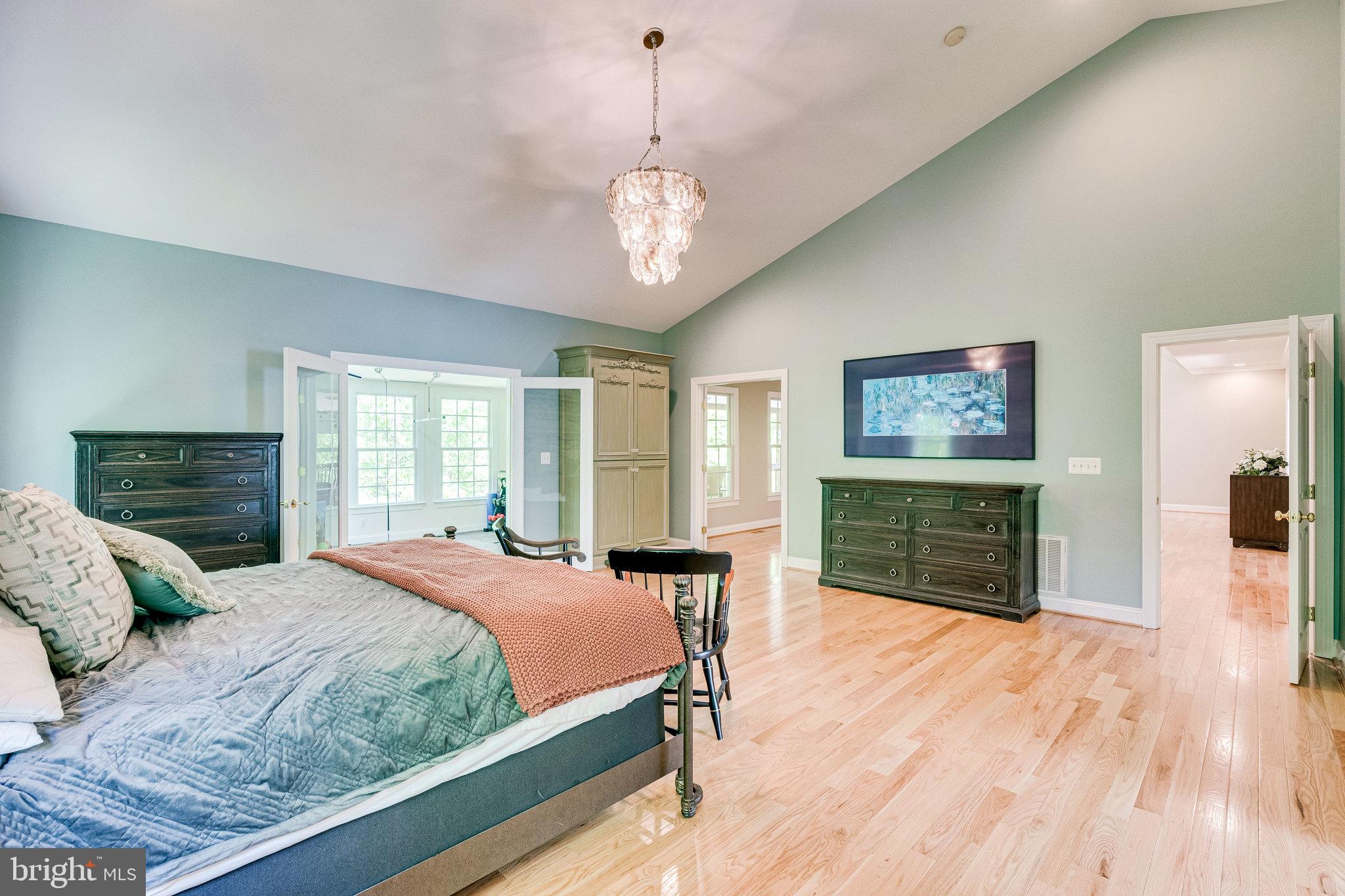 7802 Creekside View Lane Springfield, VA 22153 - Photo 41 of 107 a bedroom with a large bed a chandelier and dresser