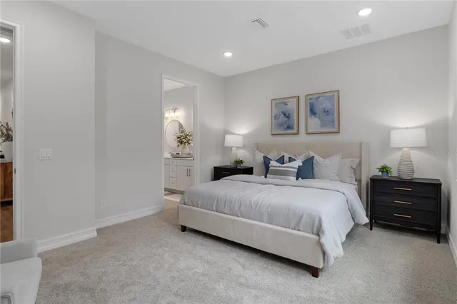 a spacious bedroom with a bed and a lamp