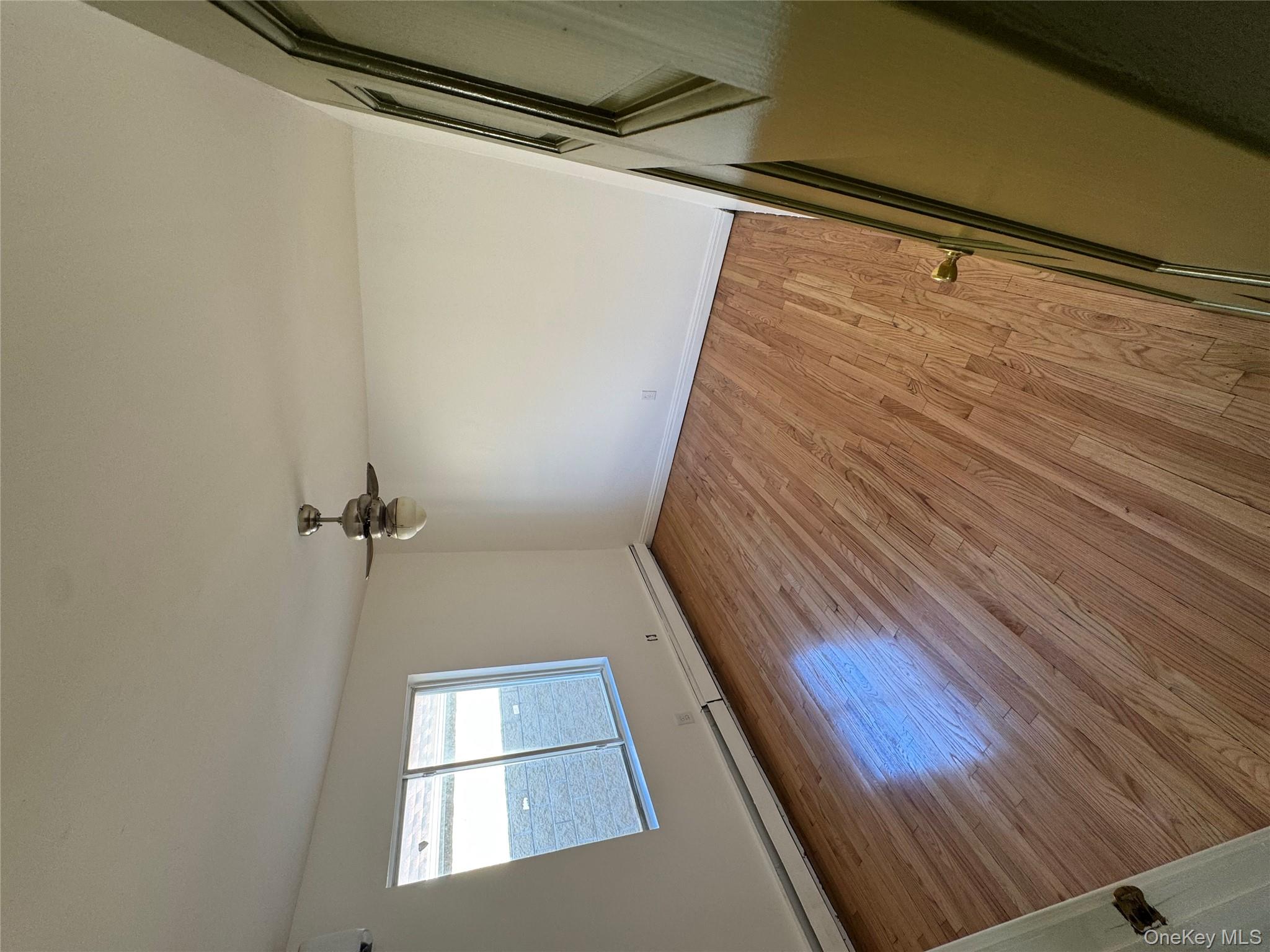 103-14 169th Street Queens, NY 11433 - Photo 11 of 18 Spare room with baseboard heating, light wood-style flooring, and ceiling fan