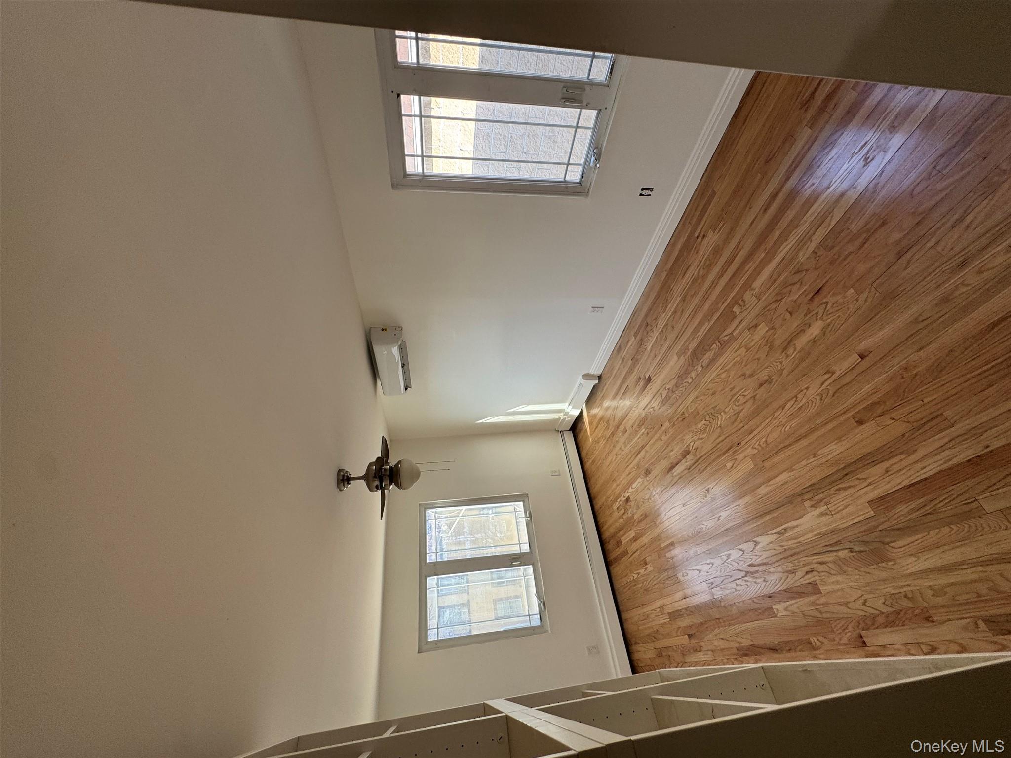 103-14 169th Street Queens, NY 11433 - Photo 13 of 18 Empty room featuring plenty of natural light, light wood-type flooring, and a ceiling fan