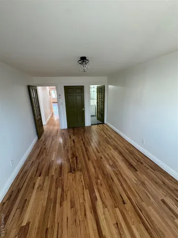 a view of a room with wooden floor and window
