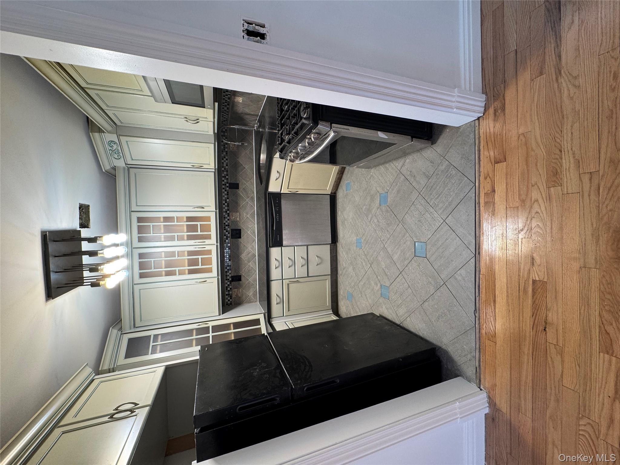 103-14 169th Street Queens, NY 11433 - Photo 6 of 18 Kitchen with dark countertops, refrigerator, range, dishwasher, and light wood-type flooring