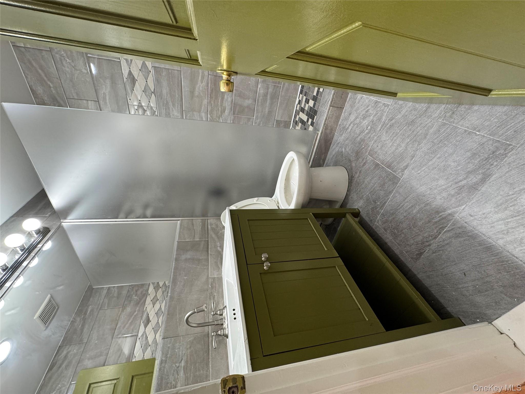 103-14 169th Street Queens, NY 11433 - Photo 10 of 18 Full bathroom featuring tile walls, vanity, and walk in shower