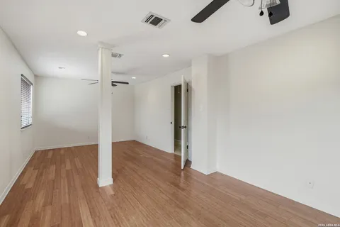 a view of an empty room with wooden floor