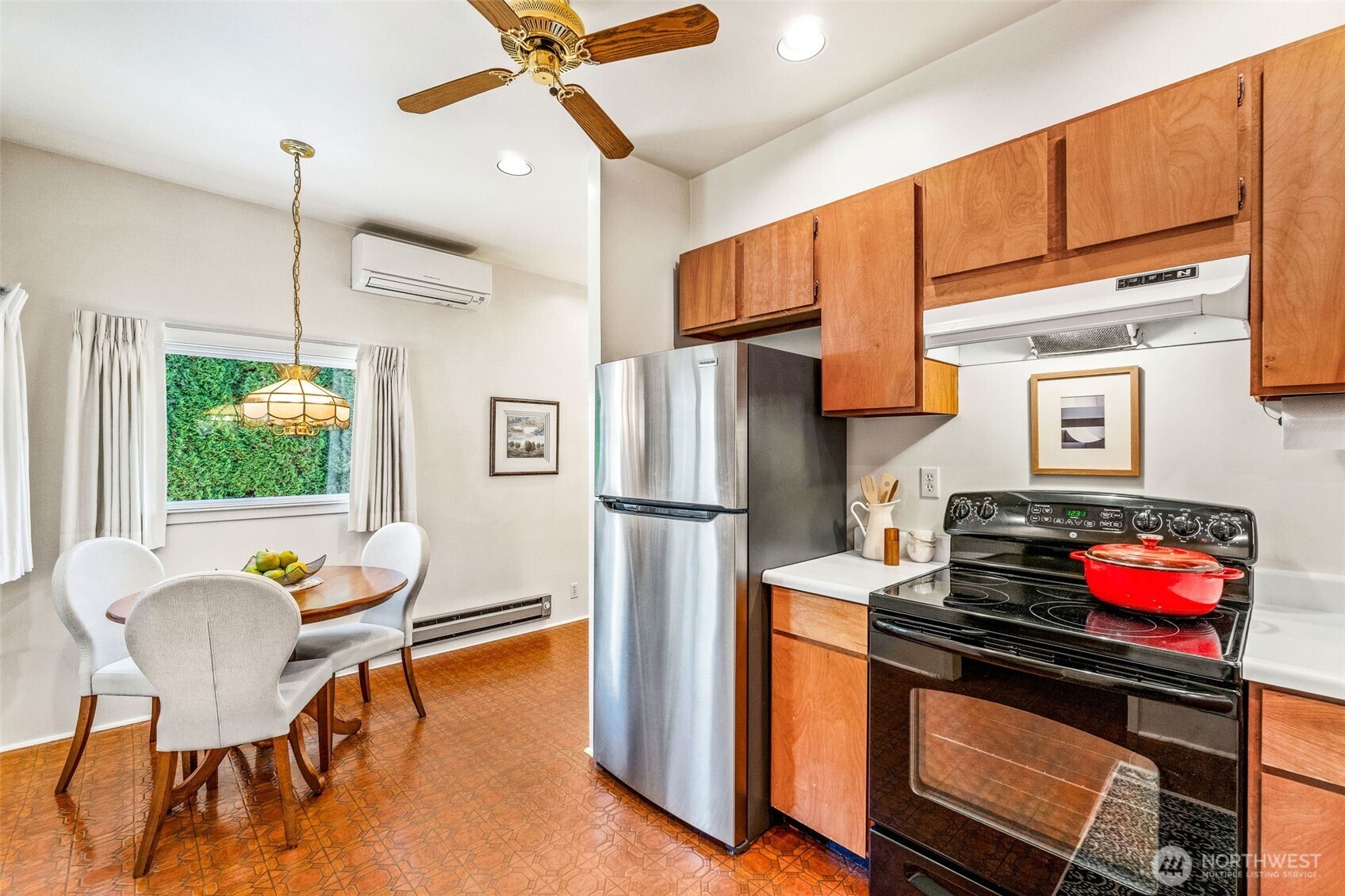 2358 Northwest 73rd Street Seattle, WA 98117 - Photo 9 of 18 a kitchen with stainless steel appliances granite countertop a stove refrigerator a dining table and chairs with wooden floor