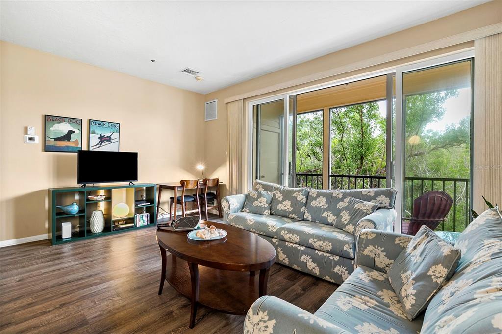 619 Cedars Court Longboat Key, FL 34228 - Photo 57 of 95 a living room with furniture a flat screen tv and a large window