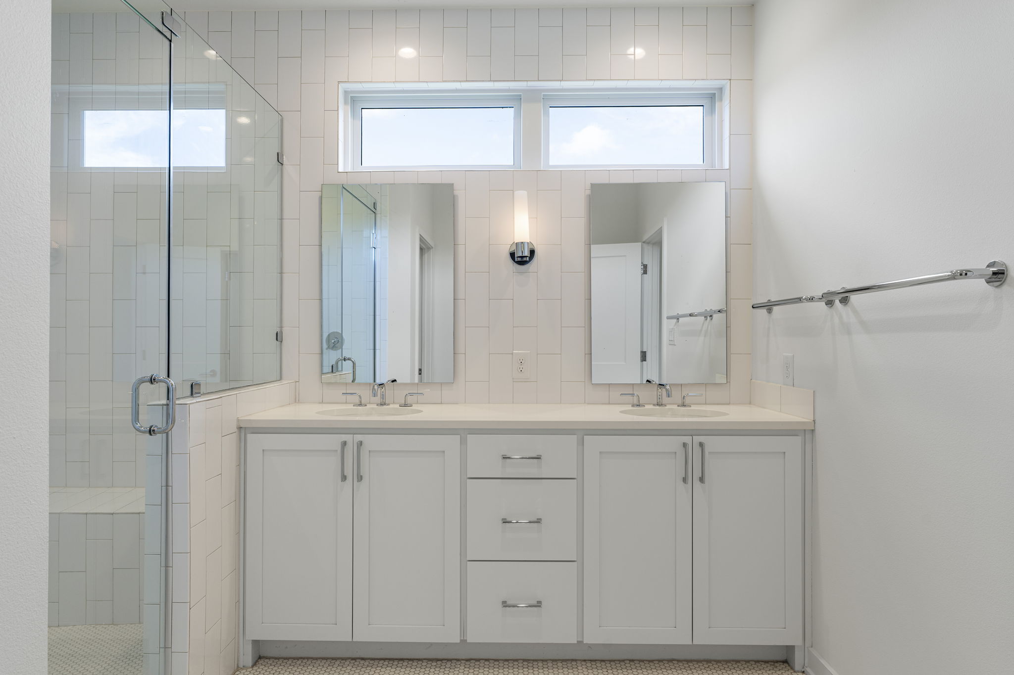 2520 Sutherland Street Austin, TX 78746 - Photo 17 of 26 A chic primary bathroom offers a dual vanity, sleek frameless shower, and elegant tile work with a seperate toilet closet and grand walk in closet.