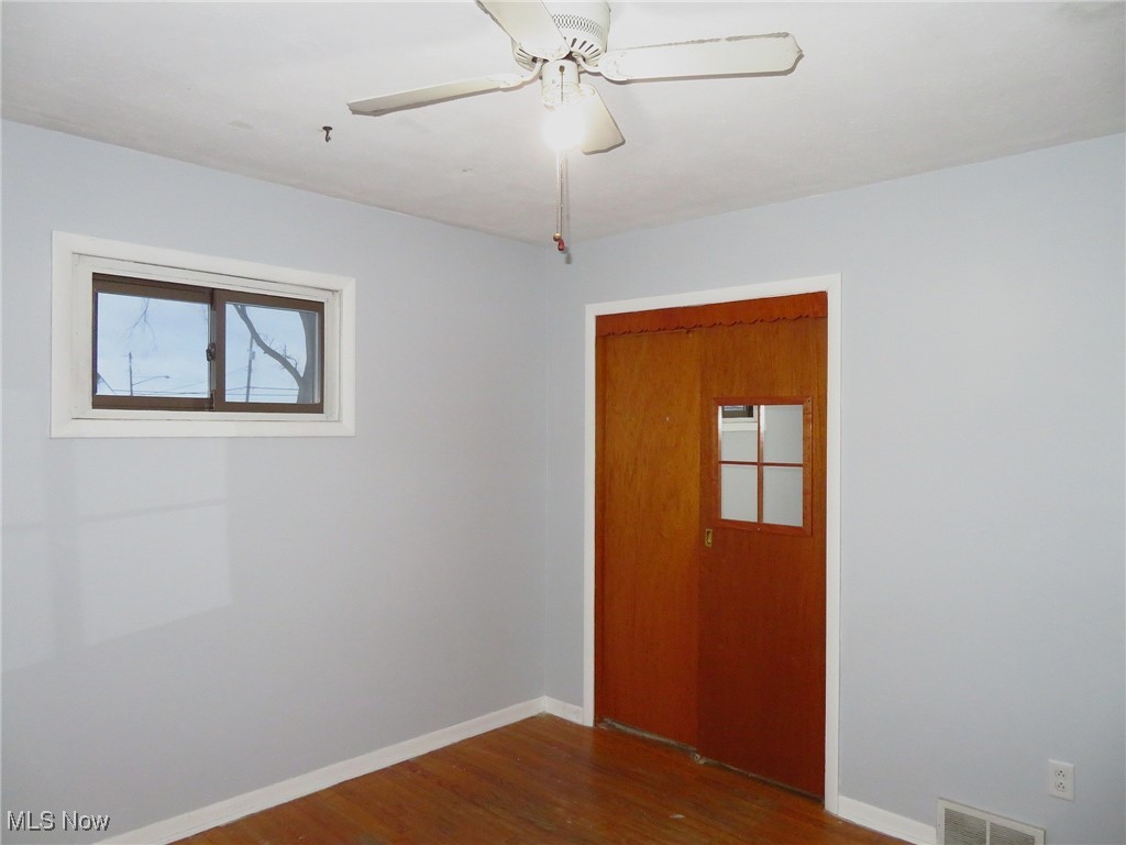 12214 Thompson Road Vermilion, OH 44089 - Photo 16 of 29 Double closet in bedroom 2, with a ceiling fan/light & hardwood flooring