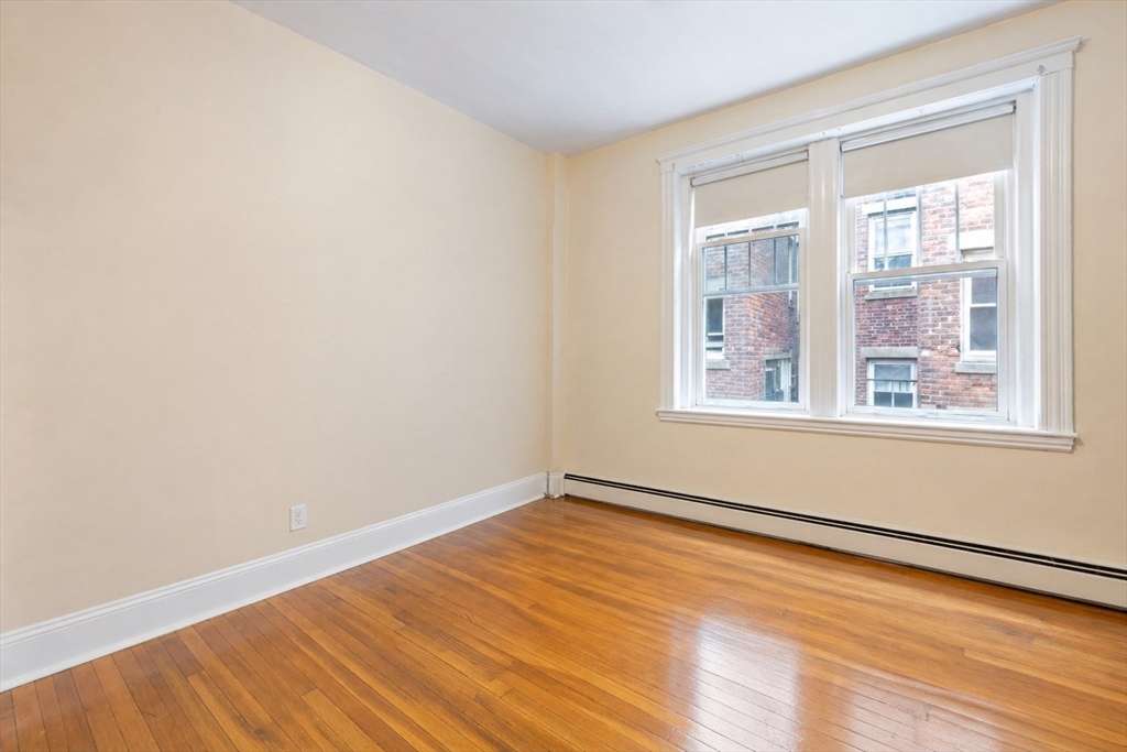 21 Sutherland Road, Unit 6 Boston, MA 02135 - Photo 7 of 20 a view of an empty room with wooden floor and a window