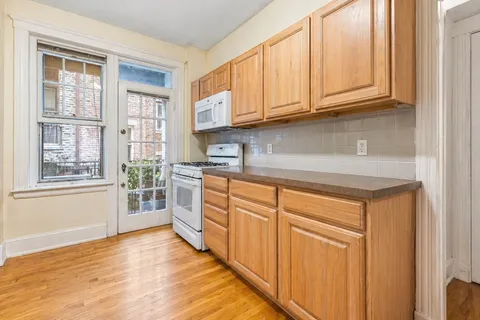 a kitchen with stainless steel appliances granite countertop a stove a sink and a granite counter tops with white cabinets