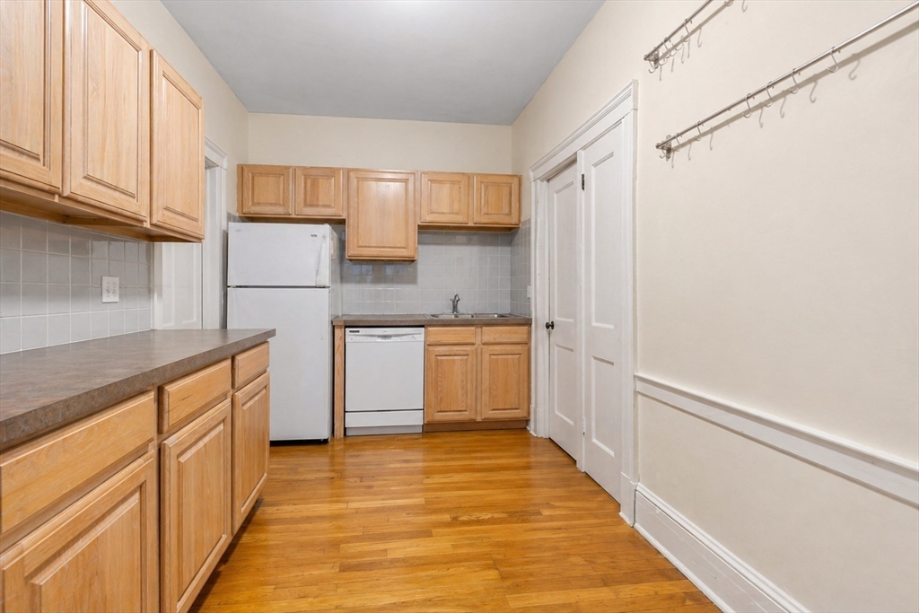 21 Sutherland Road, Unit 6 Boston, MA 02135 - Photo 9 of 20 a kitchen with a sink a stove top oven and white cabinets