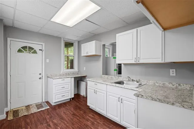a kitchen with granite countertop white cabinets and white appliances