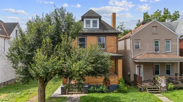 a front view of a house with yard and green space