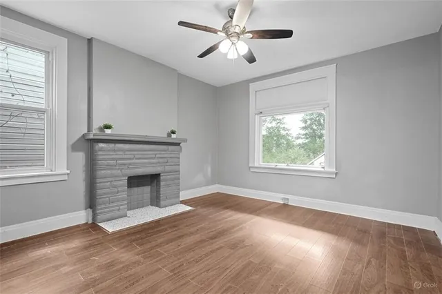 a view of empty room with fireplace and wooden floor
