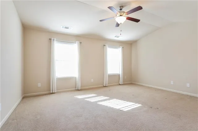 an empty room with fan and windows