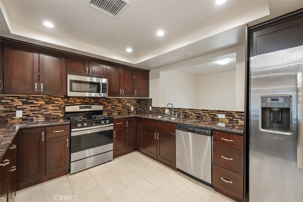 900 Dwight Avenue, Unit 108 Compton, CA 90220 - Photo 15 of 49 a kitchen with stainless steel appliances granite countertop a stove top oven a sink dishwasher a refrigerator and a microwave oven