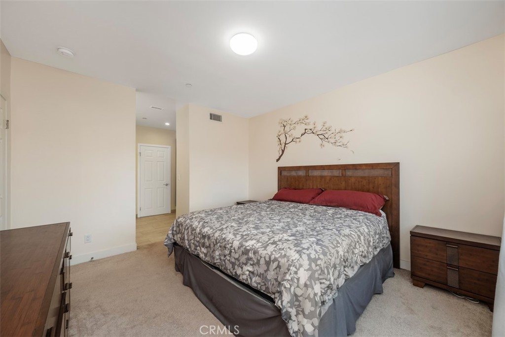 900 Dwight Avenue, Unit 108 Compton, CA 90220 - Photo 37 of 49 a bedroom with a bed and a night stand