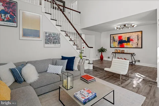 a living room with furniture kitchen view and a large window