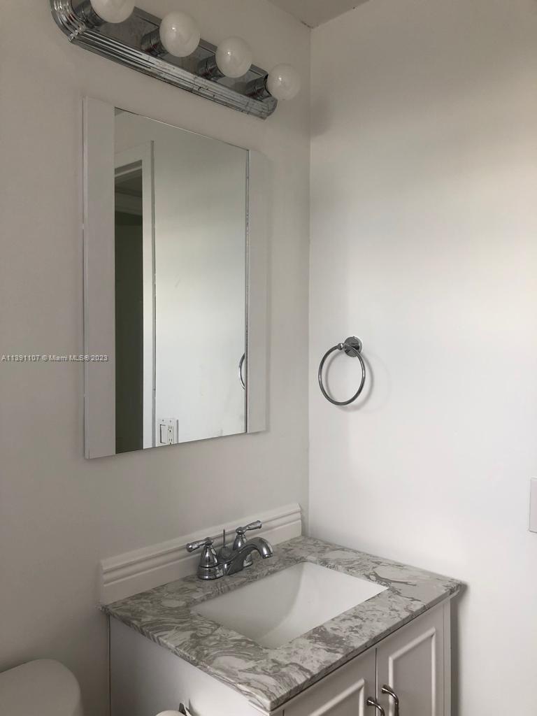 Shorecrest Miami, FL 33138 - Photo 11 of 18 a bathroom with a granite countertop sink and a mirror