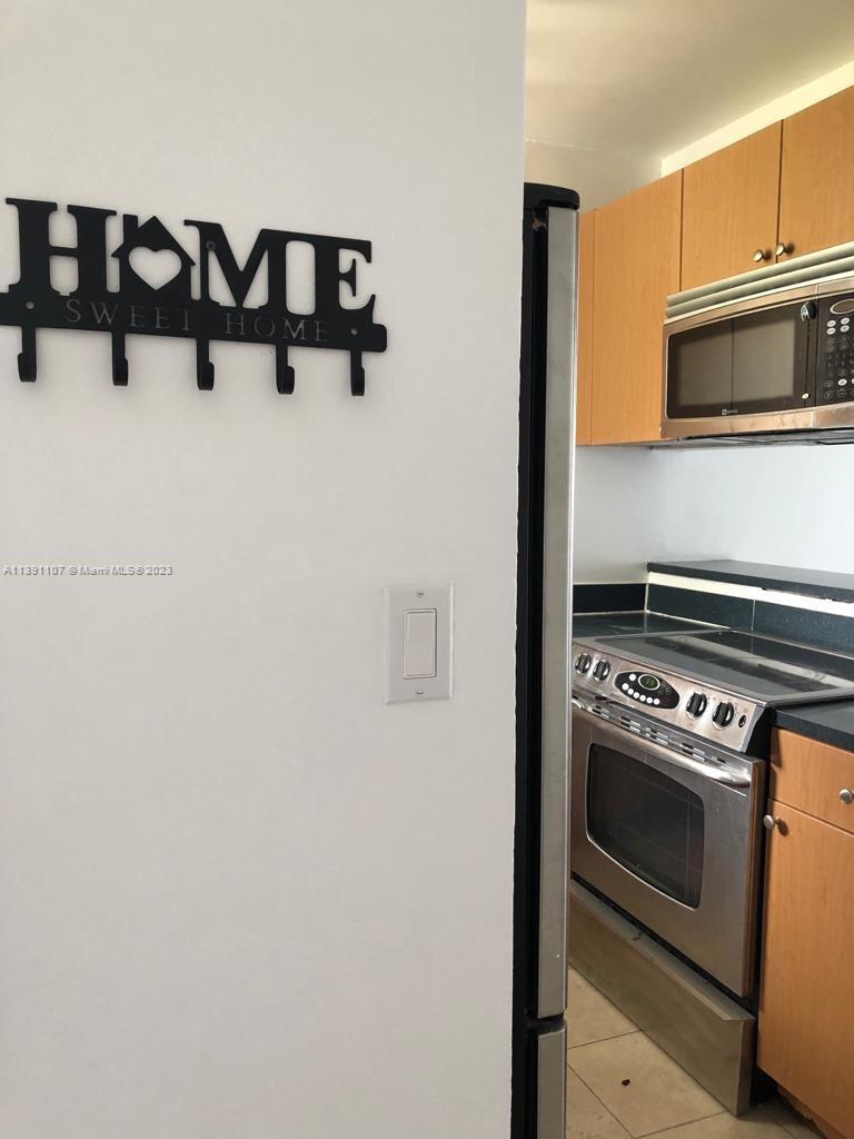 Shorecrest Miami, FL 33138 - Photo 18 of 18 a kitchen with white cabinets and black appliances