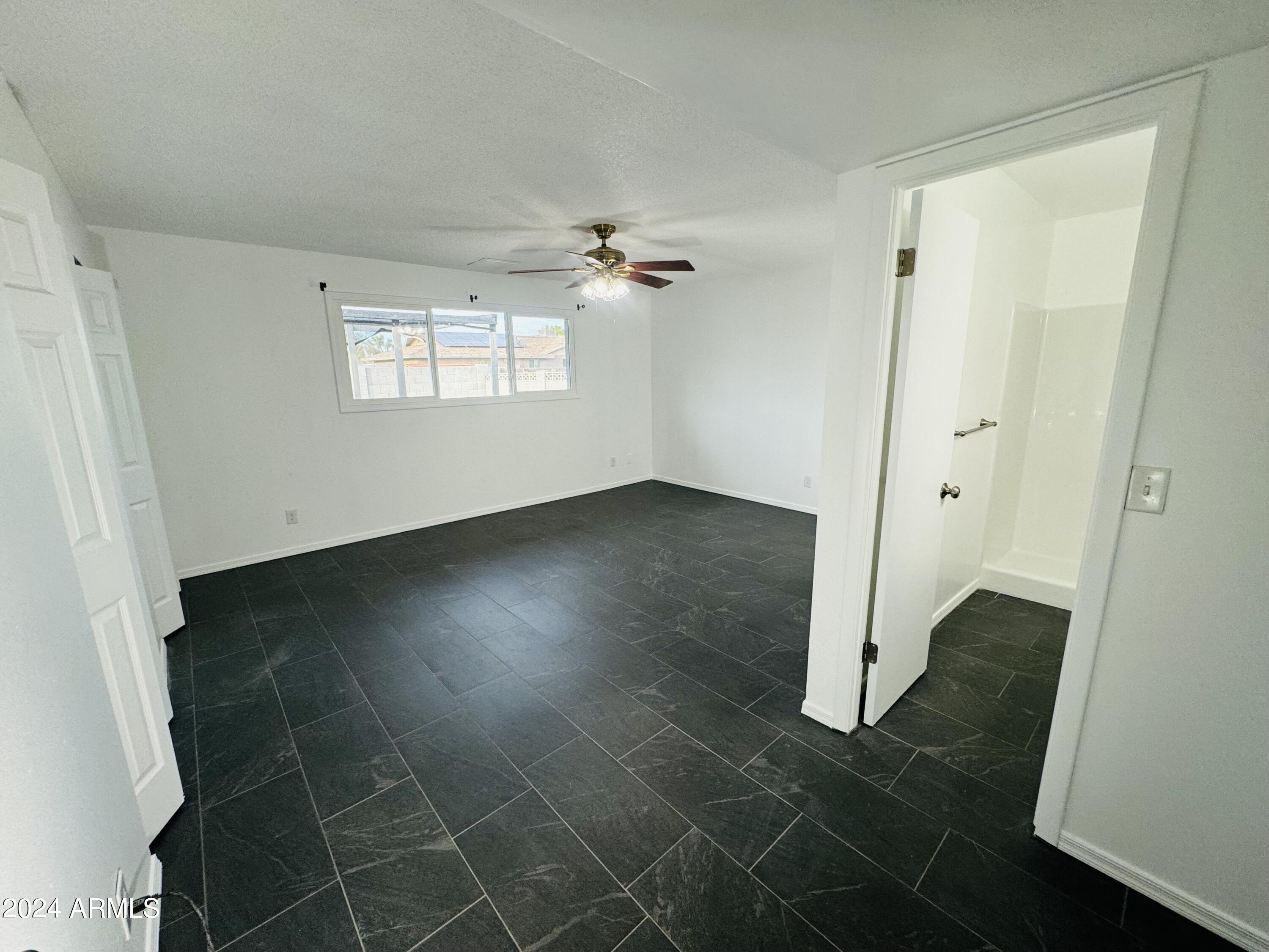 1216 East Riviera Drive Tempe, AZ 85282 - Photo 12 of 33 an empty room with a window and a ceiling fan