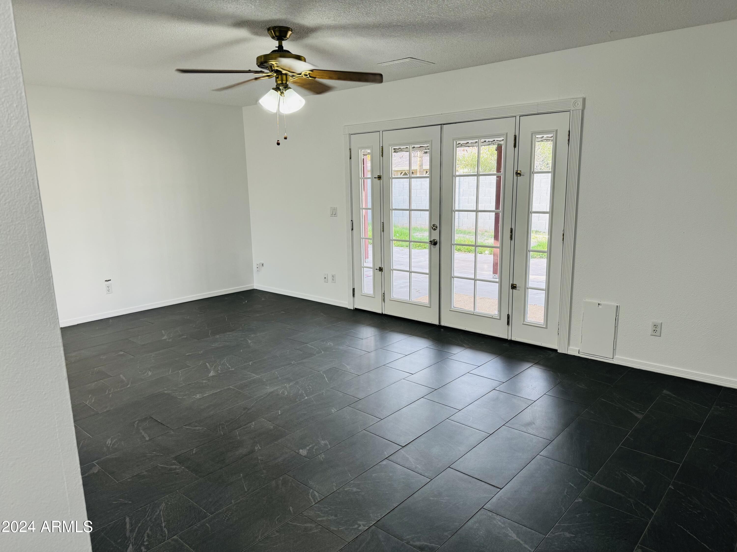 1216 East Riviera Drive Tempe, AZ 85282 - Photo 7 of 33 an empty room with chandelier fan and windows