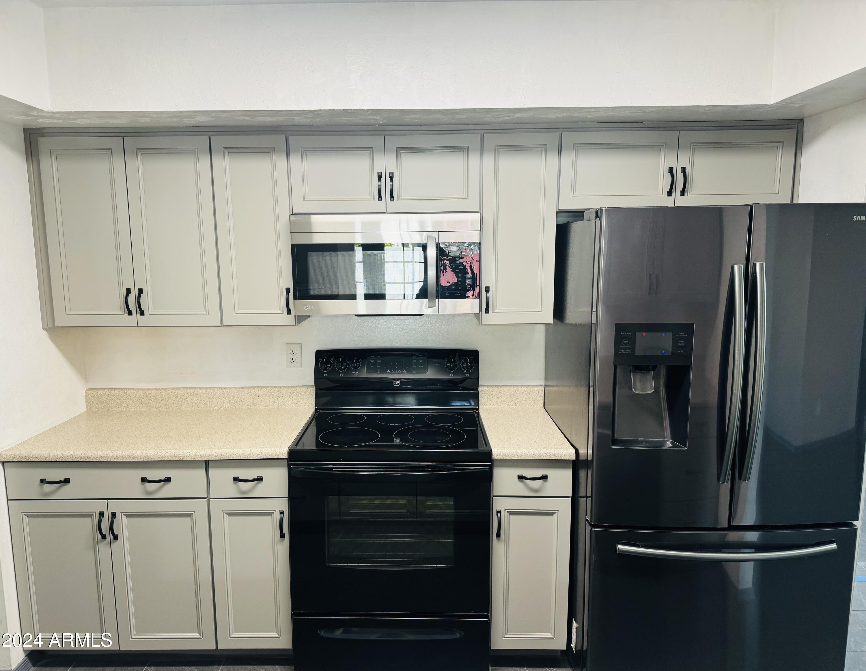 1216 East Riviera Drive Tempe, AZ 85282 - Photo 9 of 33 a kitchen with refrigerator a microwave and cabinets
