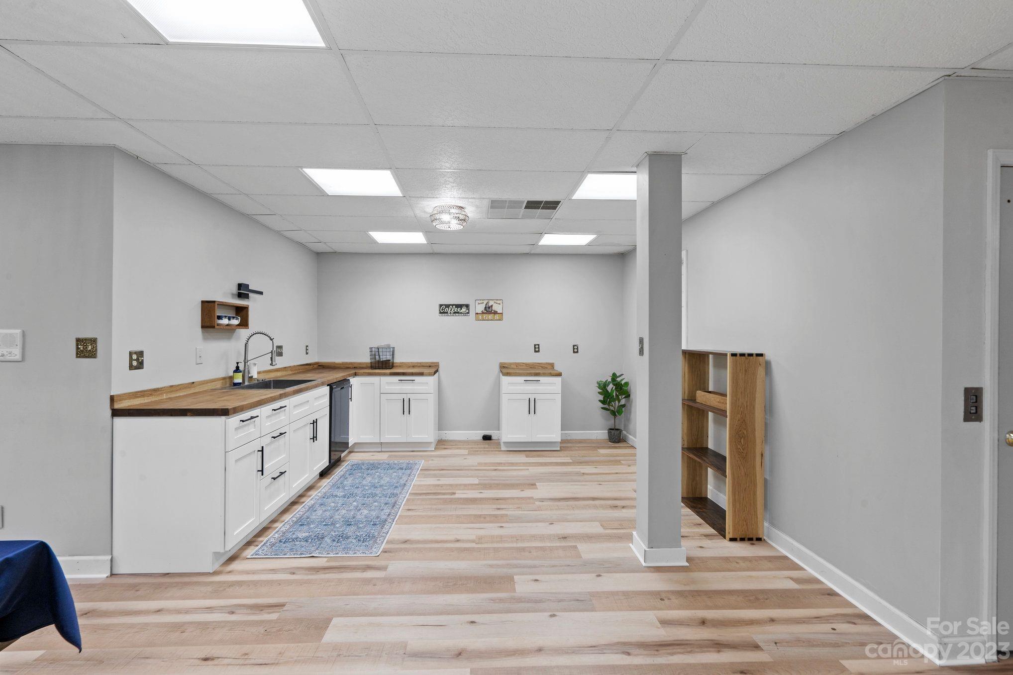 1807 David Drive Shelby, NC 28150 - Photo 21 of 37 a large white kitchen with granite countertop a stove top oven a sink dishwasher and a dining table with wooden floor