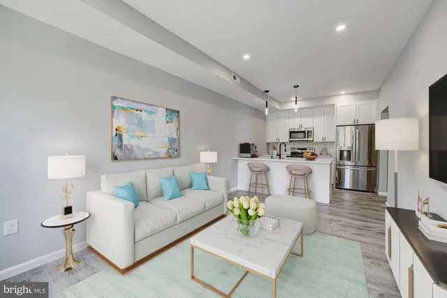 a living room with furniture and kitchen view