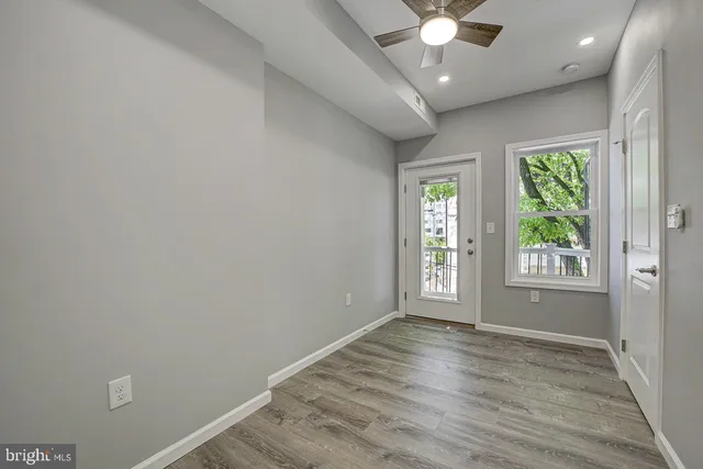 an empty room with wooden floor and windows